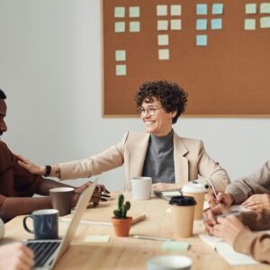 Business professionals engaged in a collaborative meeting in a modern office setting, sharing ideas and smiling.